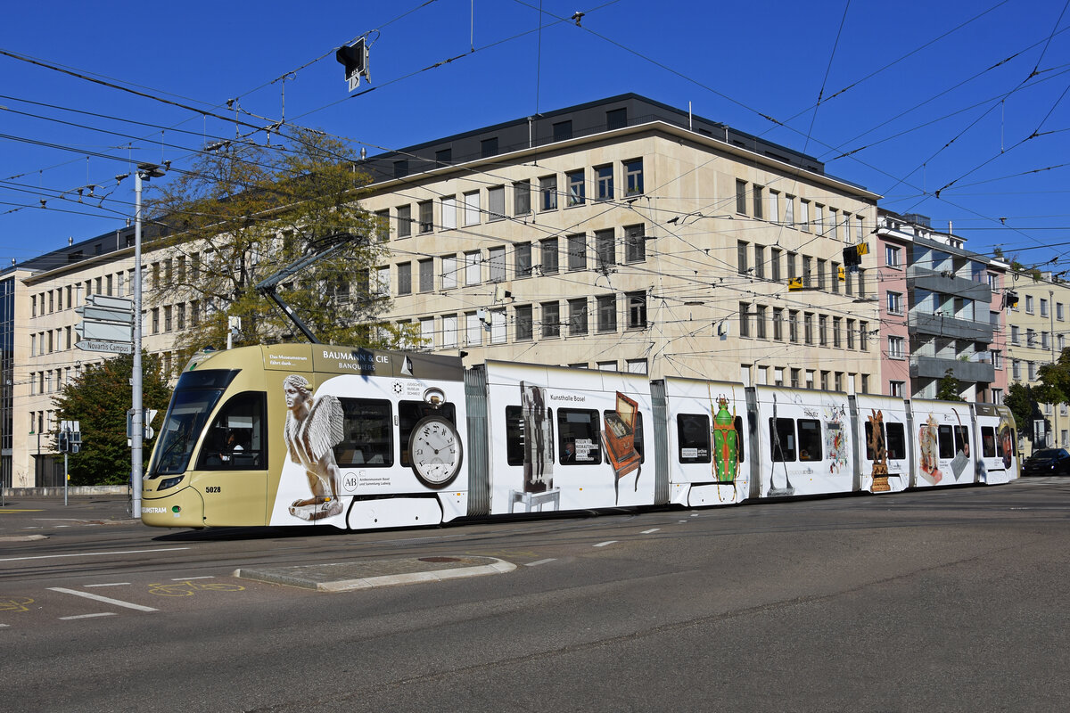 Be 6/8 Flexity 5028 mit Werbung für Basler Museen, auf der Linie 1, fährt bei der Haltestelle Dreirosenbrücke ein. Die Aufnahme stammt vom 14.10.2021.