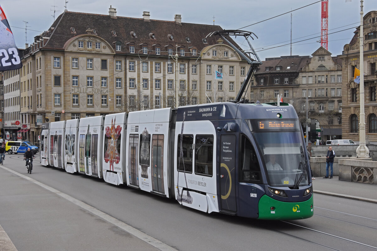 Be 6/8 Flexity 5028 mit der Werbung für die Basler Museen, auf der Linie 6, überquert am 12.04.2023 die Mittlere Rheinbrücke. Nach einer Kollision hat der Wagen eine grüne Front.
