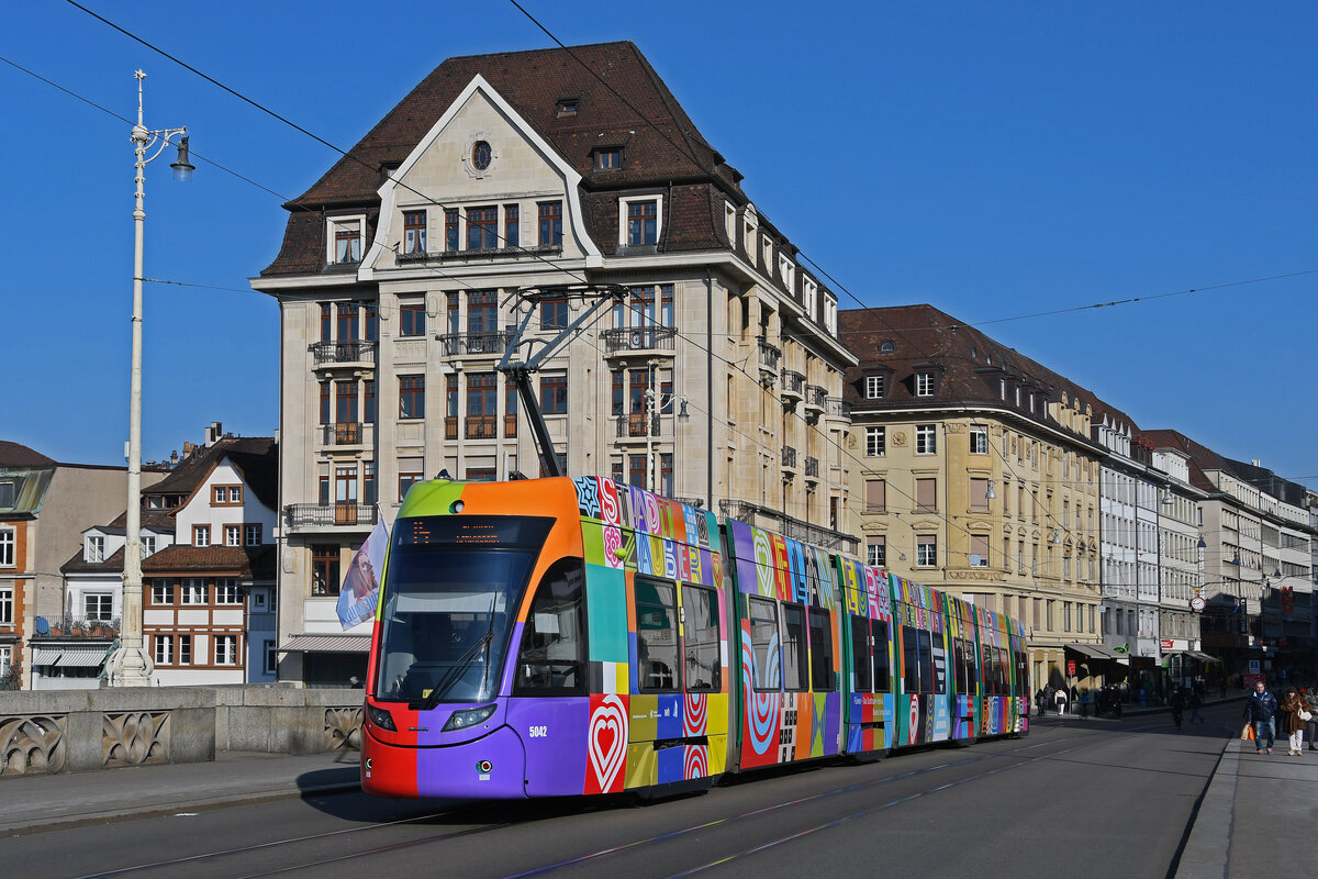 Be 6/8 Flexity 5042  Flaneur Stadt Zauber , auf der Linie 14, überquert am 09.02.2023 die Mittlere Rheinbrücke.