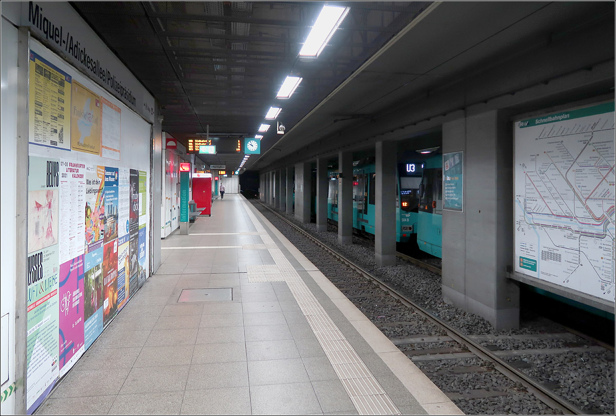 Beengte Untergrundstation -

Die Stationen der ersten 1968 eröffneten U-Bahnstrecke (A-Strecke) in Frankfurt sind mit die hässlichsten Untergrundstationen in Deutschland. Niedrige Decken und massive Mittelstützen sorgen für ein eingeengtes Raumgefühl mit wenig Aufenthaltsqualität. Hier die Station Miquel-/Adickesallee/Polizeipräsidium. Aus Brandschutzgründen wurde die abgehängte Decke entfernt und so wirkt diese jetzt sehr roh. Die Station erinnert auch an die Subway-Stationen in Seoul, wobei da jetzt überall Bahnsteigtüren eingebaut wurden, was bei Seitenbahnsteigstationen das Raumgefühl weiter einschränken.

Nahezu alle unterirdische Stationen in Frankfurt die bis 1980 gebaut wurden, auch die der S-Bahn, hinterlassen diesen negativen Eindruck. Auch wirken sie ungepflegt.

Erst mit Verlängerung der A-Strecke zum Südbahnhof 1984 wurden die Stationen freundlicher und großzügiger gestaltet.

21.07.2021 (M)
