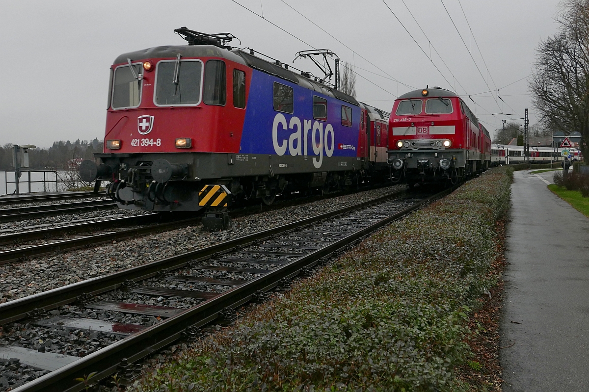 Begegnung auf dem Bodenseedamm - Einfahrt des von Re 421 394-8 gezogenen EC 195, Zrich - Mnchen, in den Lindauer Hauptbahnhof. 218 419-0 und 218 433-1 stehen bereit, um die Wagen des EuroCity zu bernehmen und nach Mnchen zu ziehen (20.02.2016).