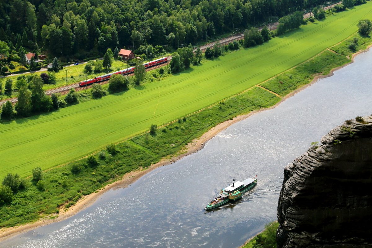 Begegnung! Während sich am 16.06.2017 der Personendampfer  Pirna  elbaufwärts kämpft, rauscht auf der Elbtalstrecke ein S-Bahnzug in Richtung Dresden. Aufnahme vom Bastei-Felsen.