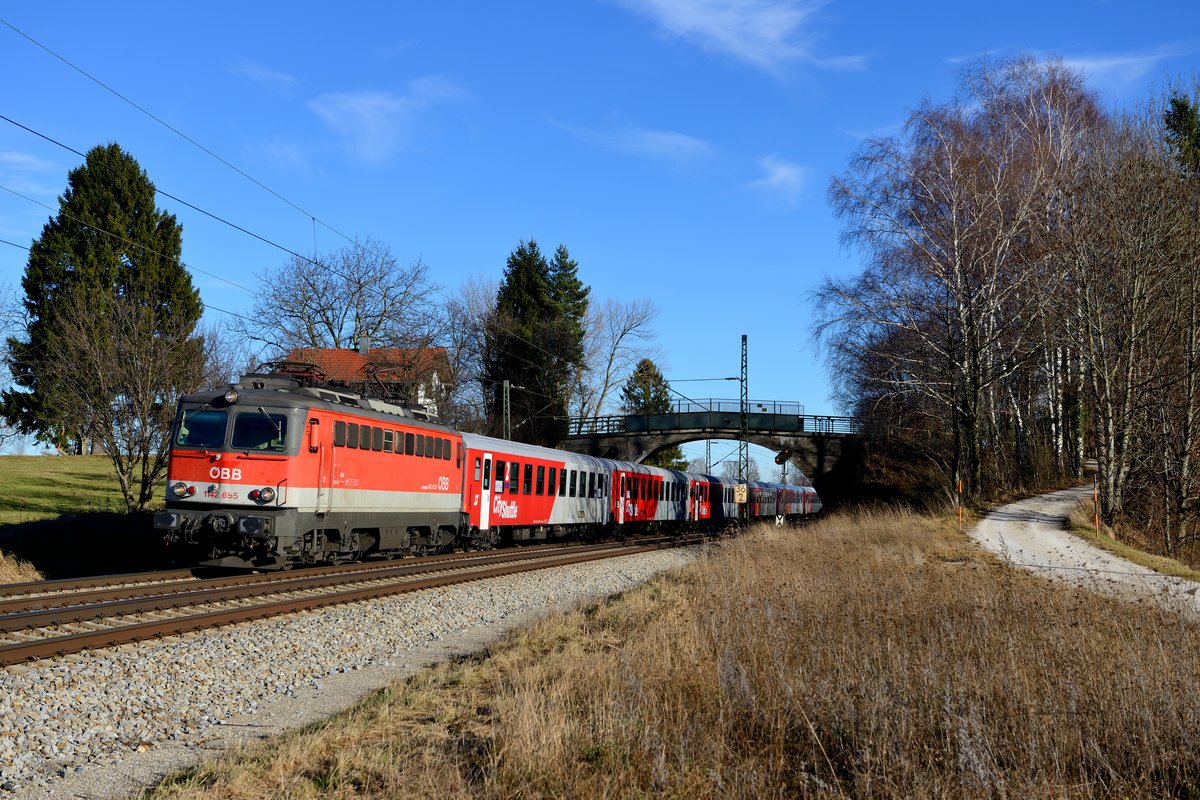 Bei der alten Stampfbeton-Feldwegbrücke bei Übersee am Chiemsee konnte der ÖBB CityShuttle als Meridian Ersatzzug M 79026 nach München abgelichtet werden. Am 17. Dezember 2013 war die 1142.655 führend, die einst den Komplettumbau im Rahmen der Hauptrevision erfahren hat (nur noch zwei Führerstandstüren mit verblechten Fenstern, kleine ÖBB Standart-Scheinwerfer, drittes Schlusslicht entfernt).