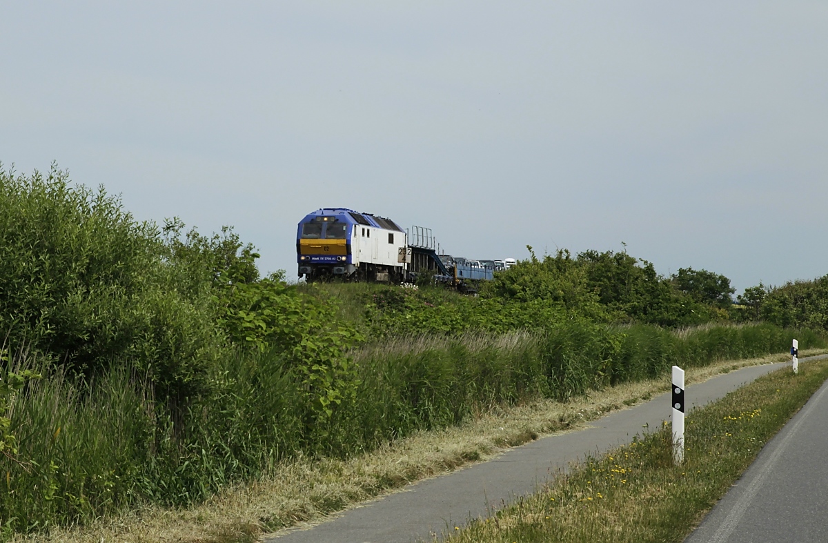 Bei Ausfall einer der beiden Vectron-Diesel kommt die MaK DE 2700-02 vor den RDC-Autozügen nach Sylt zum Einsatz. Dies war am 18.06.2020 der Fall, hier bringt die Lok einen Autozug nach Westerland, aufgenommen kurz vor dem Bahnhof Keitum.