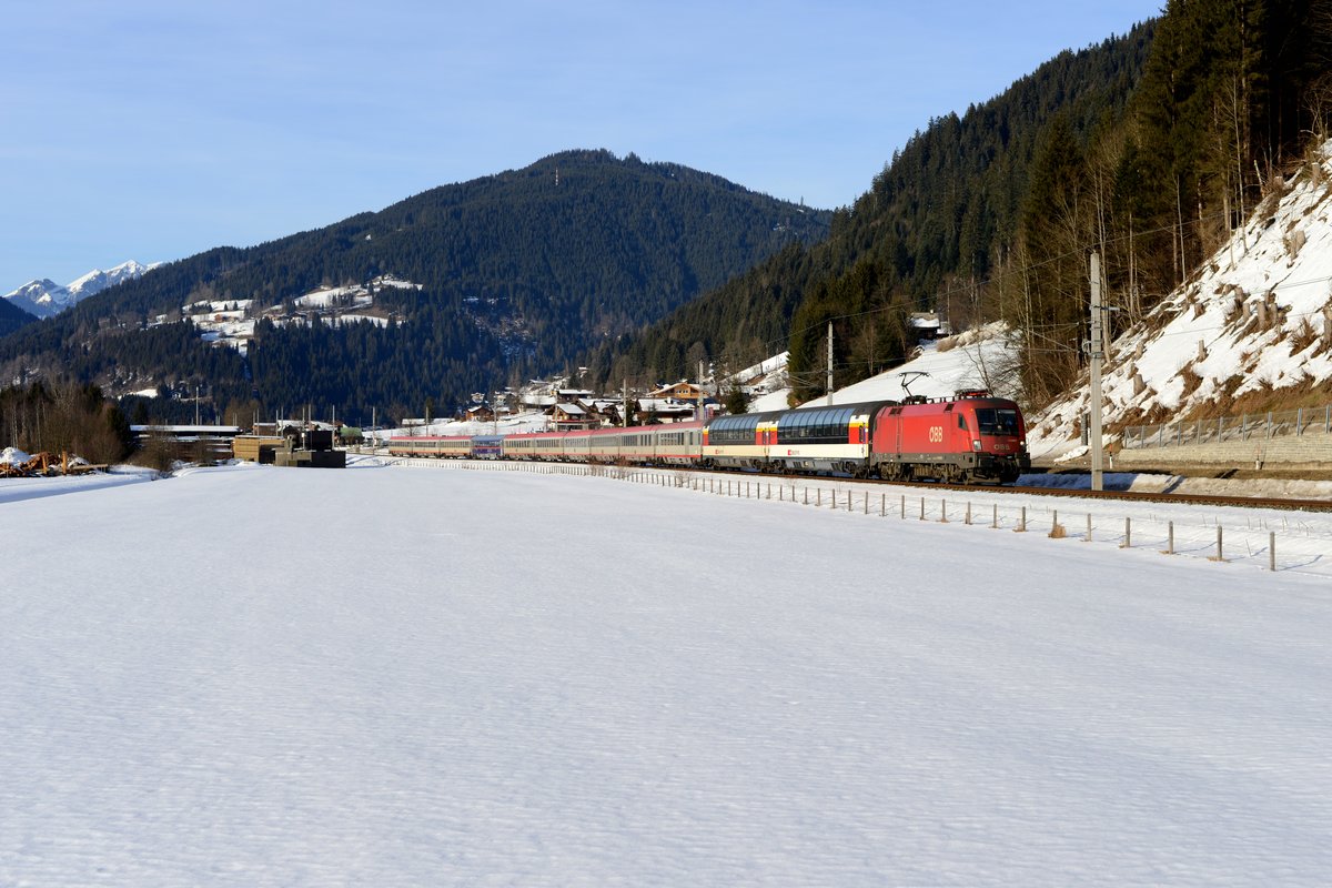 Bei Eben im Pongau erwartete ich den  Starzug  des Ennstales, den EC 163 von Zürich HB nach Graz HBF. Geführt wurde er von 1116.025, der zum Aufnahmezeitpunkt eine Wäsche gut zu Gesicht gestanden hätte. Entschädigt wurde man durch die interessante Zugbildung an diesem 11. Februar 2017: Gleich zwei Panoramawagen der SBB befanden sich im Zugverband und zusätzlich noch ein in der neuen  NightJet -Lackierung gehaltener Bmz 21-91. Im Pongau fand man an diesem Tag noch winterliche Verhältnisse vor, die warmen Temperaturen setzten der Schneedecke allerdings bereits massiv zu...