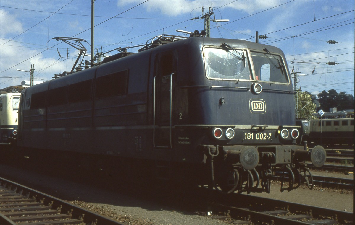 Bei einem begleiteten BW-Rundgang im Sommer 1991 entstand diese Aufnahme von 181 002-7 im damaligen  BW Saarbrucken 1 . Damals war die gesamte Reihe 181, inklusive der Vorserienloks, noch in Saarbrucken stationiert und auch im Einsatz. Die Vorserienfahrzeuge fuhren aber auch damals schon fast nur noch im Güterverkehr zwischen Saarbrucken und Forbach bzw. Trier und Apach, zusammen mit der Baureihe 184. Nikon F-301 - Scan vom Dia. 