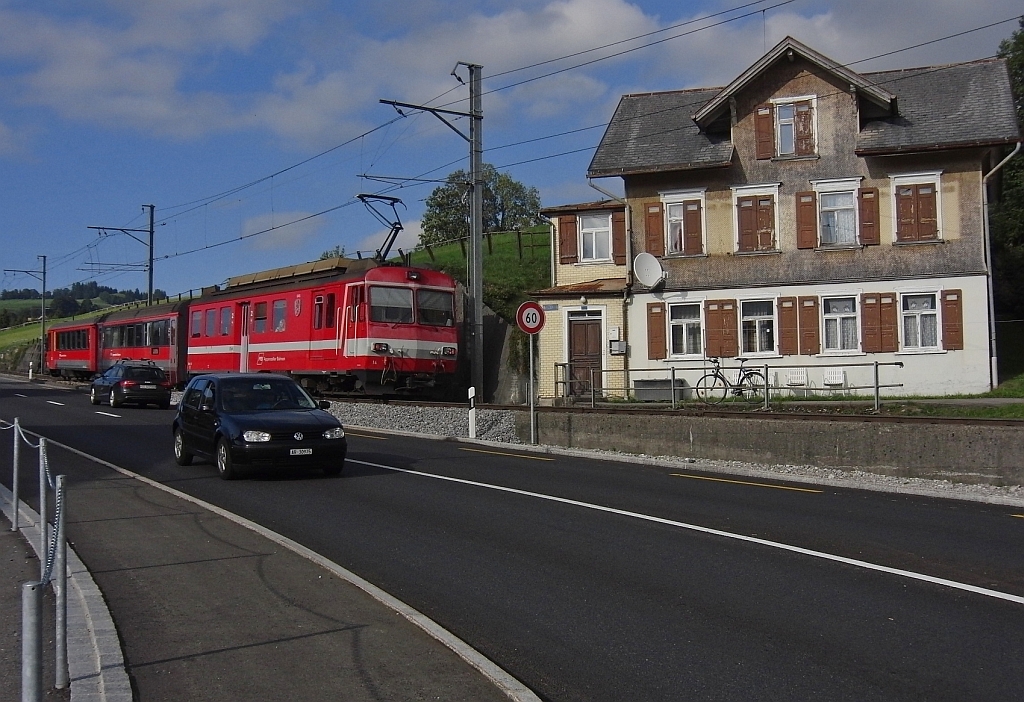 Bei einem Groteil der Strecke zwischen Appenzell und St. Gallen liegen die Gleise der Appenzeller Bahn parallel zur Strae. Wie auch hier in Hirschberg, nachdem S11 2166 nach St. Gallen gerade die gleichlautende Haltestelle verlassen hat (21.09.2013).
