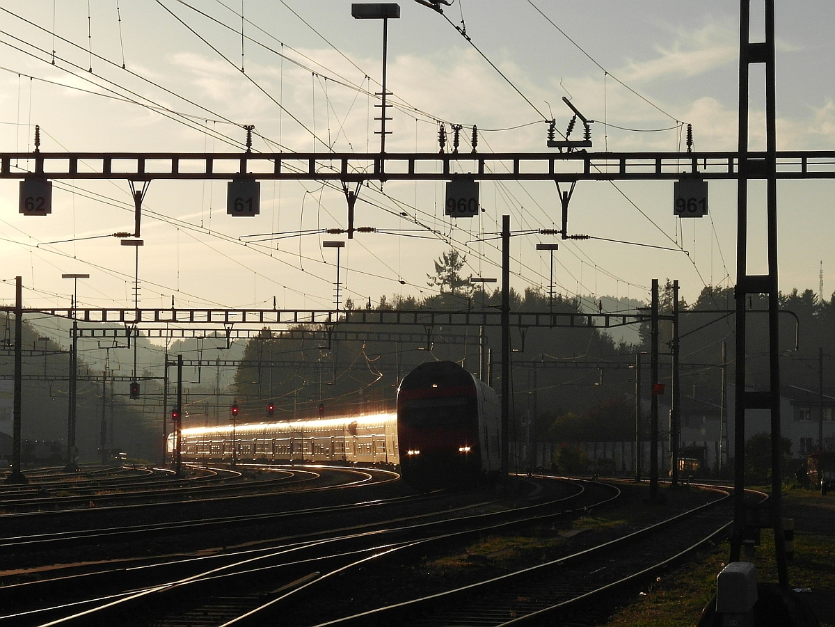 Bei der Einfahrt in den Bahnhof von Wil (SG) bringt die untergehende Sonne die Wagen des IC 727, Genve-Aroport - St. Gallen, zum Glnzen (01.11.2014).