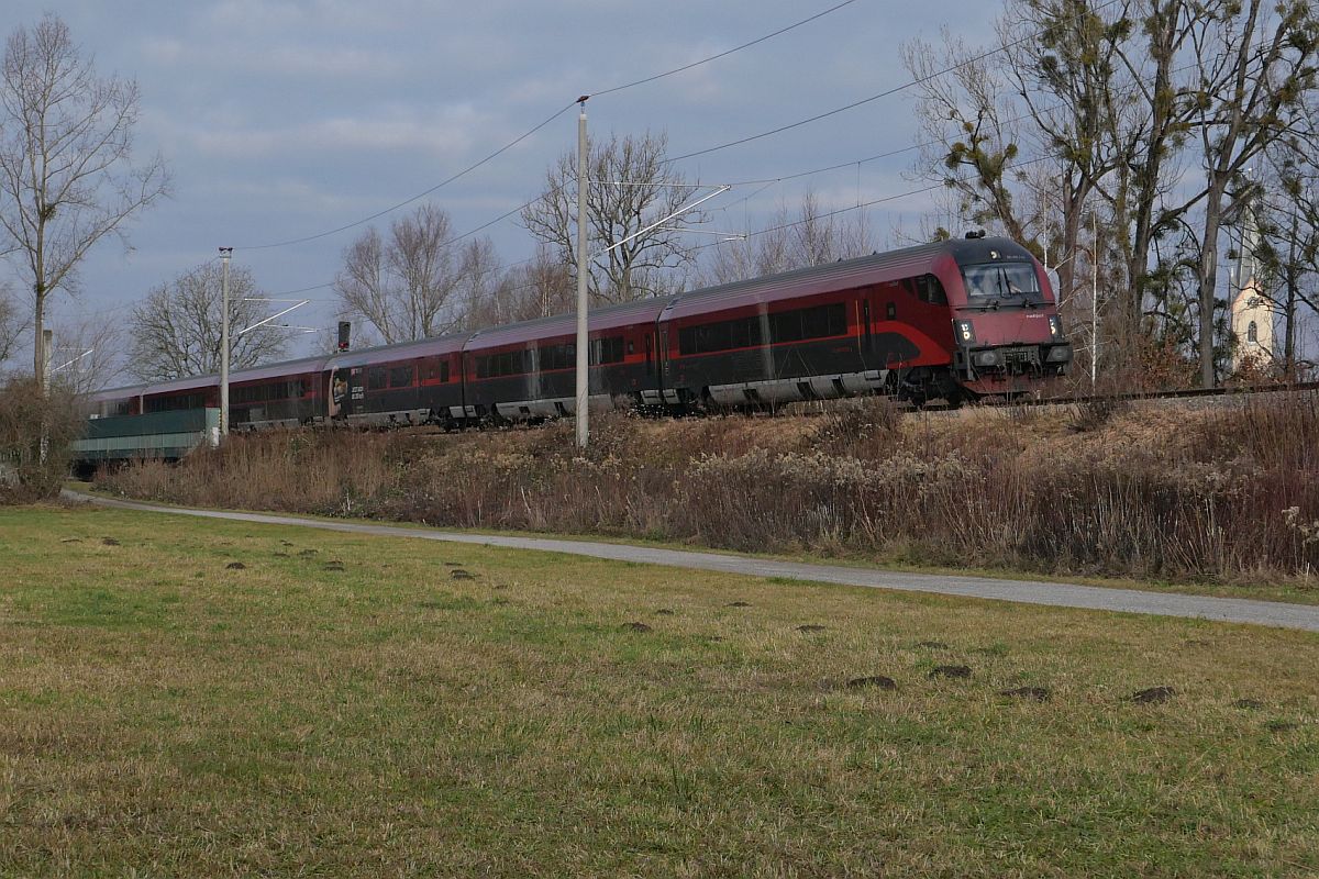 Bei Eriskirch befindet sich der von Frankfurt (Main) kommende RJX 897  BREGENZERWALD  auf der Fahrt zum Flughafen Wien (20.12.2021)