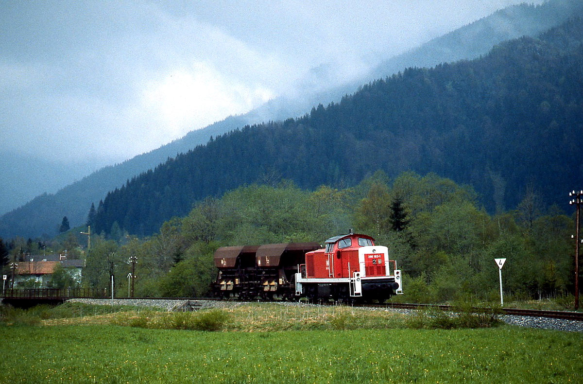 Bei Fischbachau ist 290 103-1 im Frühjahr 1989 mit zwei Schotterwagen in Richtung Bayrischzell unterwegs