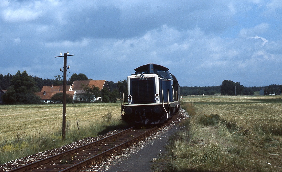Bei Greißelbach ist 211 309-0 im Juli 1985 mit einem Nahverkehrszug von Neumarkt nach Beilngries unterwegs