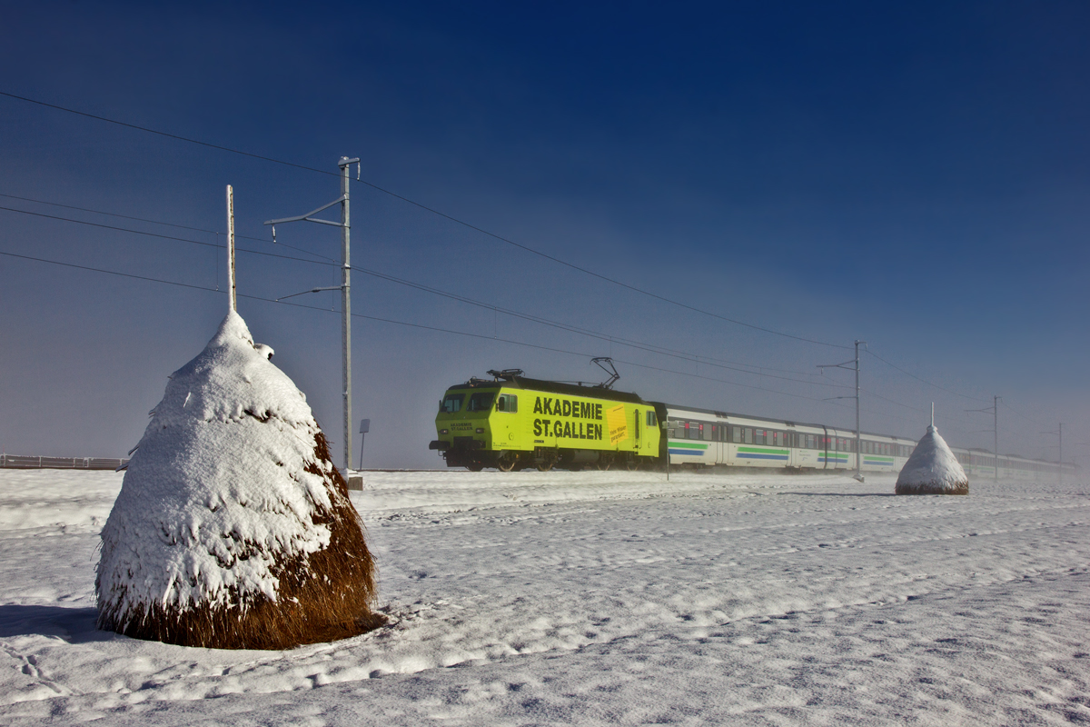 Bei der Heinze in Altmatt taucht aus dem Nebel die SOB Re 446 018  Akademie St.Gallen  mit dem Voralpenexpress auf.Bild vom 24.2.2016