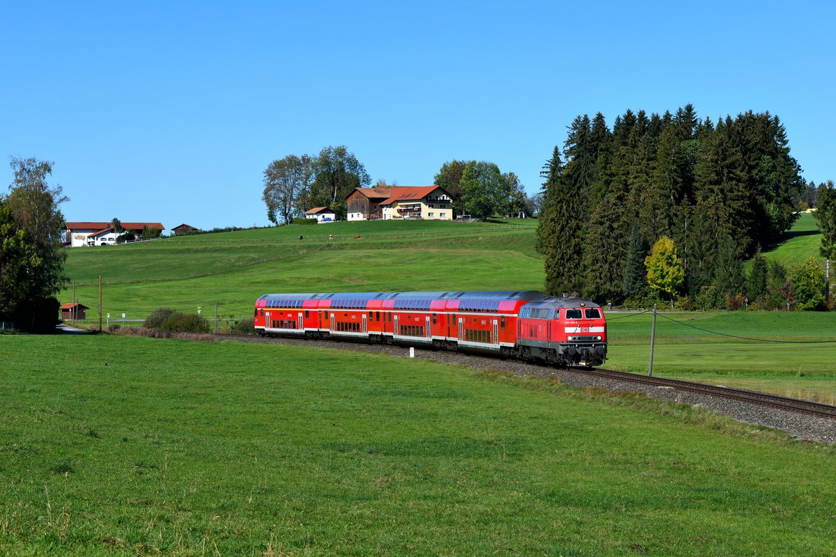 Bei Hopferau passiert die König-Ludwig-Bahn einige Gehöfte. Auch in diesem Streckenabschnitt hängt noch die Telegrafenleitung. Am 14. Oktober 2018 gelang mir hier diese Aufnahme von 218 424 mit ihrem RE 57506 auf der Fahrt nach Füssen. 