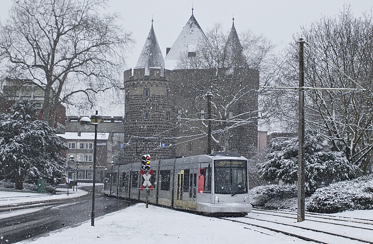 Bei leichtem Schneefall trifft der Rheinbahn-NF10 2032 am 07.02.2021 an der Haltestelle Neuss Stadthalle ein. Im Hintergrund das Obertor, das einzige erhaltene Neusser Stadttor, dessen älteste Teile aus dem 13. Jahrhundert stammen.