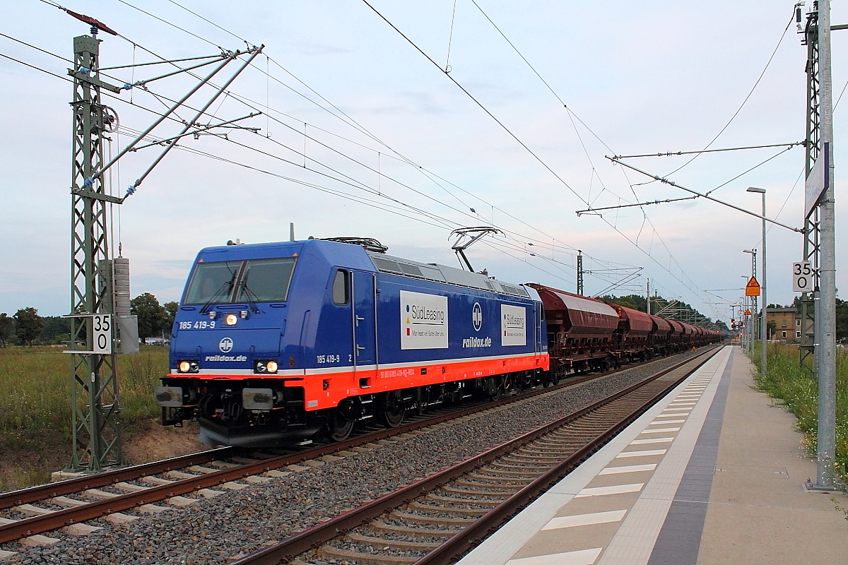 Bei letztem Licht am 15.08.2014 in Nassenheide noch erwischt - 
Die nigelnagelneue 185 419-9 der Raildox mit Schüttgutwagenzug.
Die Maschine wurde 2014 bei Bombardier in Kassel gebaut.
