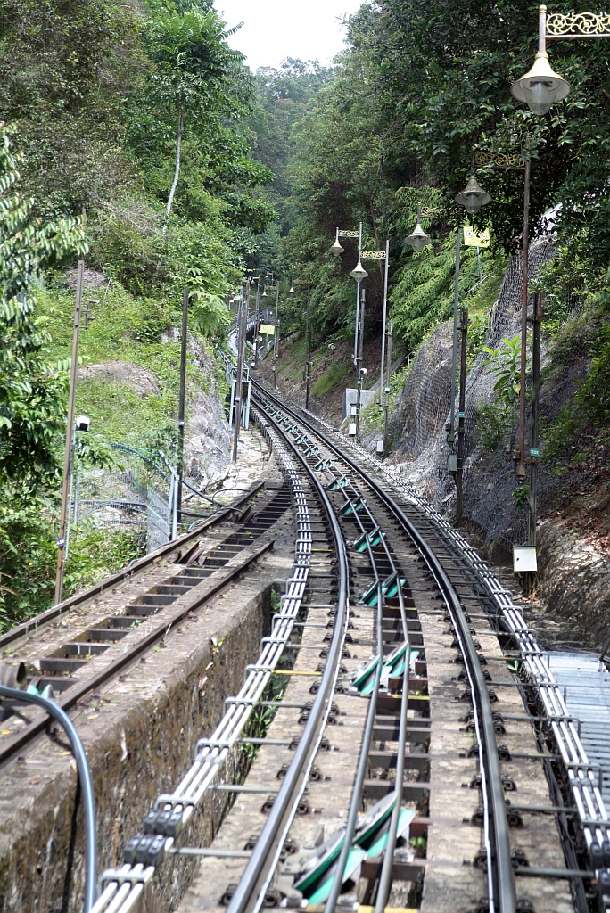 Bei der Modernisierung der KBB (Keretapi Bukit Bendera, Penang Hill Railway) vom 22.Februar 2010 bis 25.April 2011 wurde die Trasse teilweise neu gestaltet und die Züge befahren nun ohne Umsteigen in der Stesen Tengah (Middle Station) die gesamte Strecke. - Im Bild vom 18.Februar 2025 die Reste der alten Ausweiche im ehemaligem oberen Abschnitt zwischen der Stesen Claremont und der Stesen Viaduct.