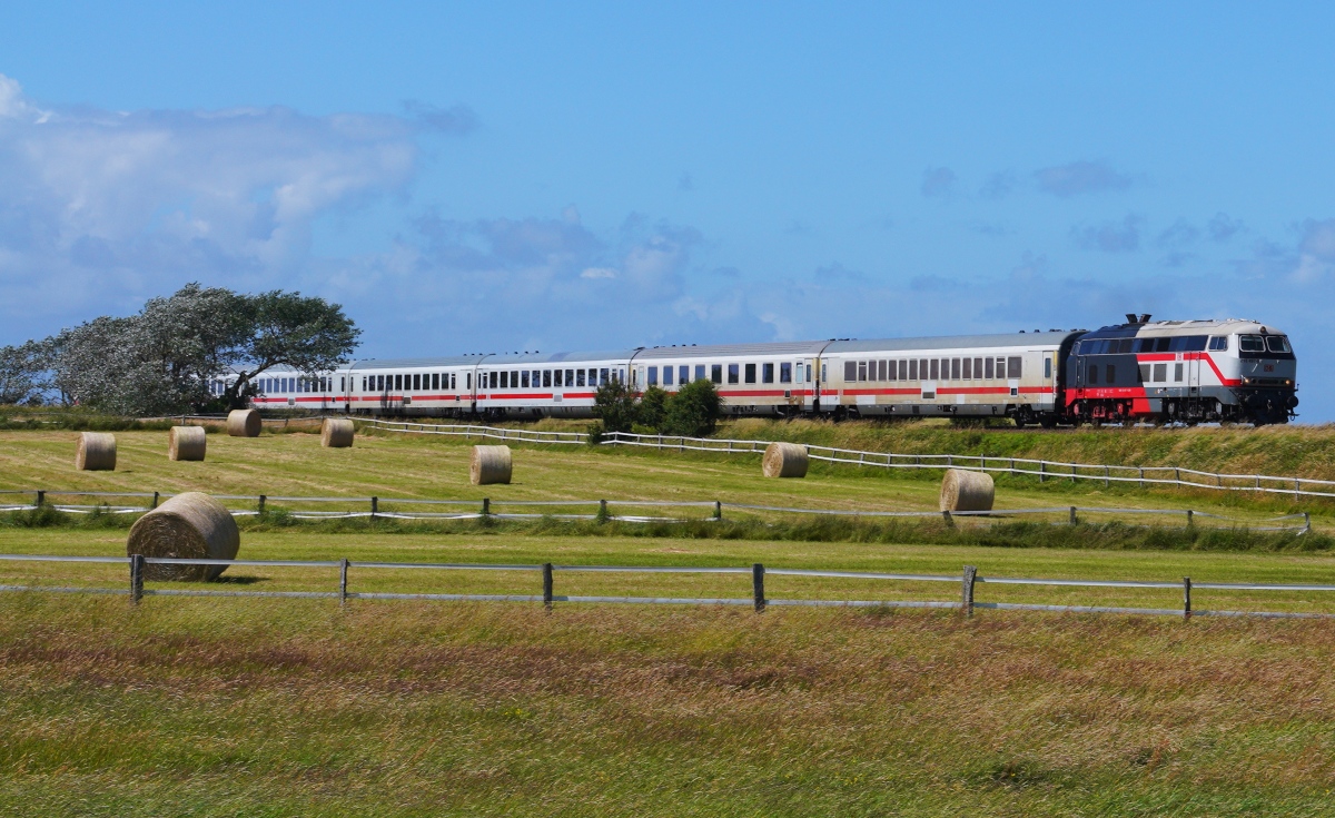Bei Morsum ist die 218 497-6 mit dem IC 2075 von Westerland nach Berlin am 28.06.2024 unterwegs
