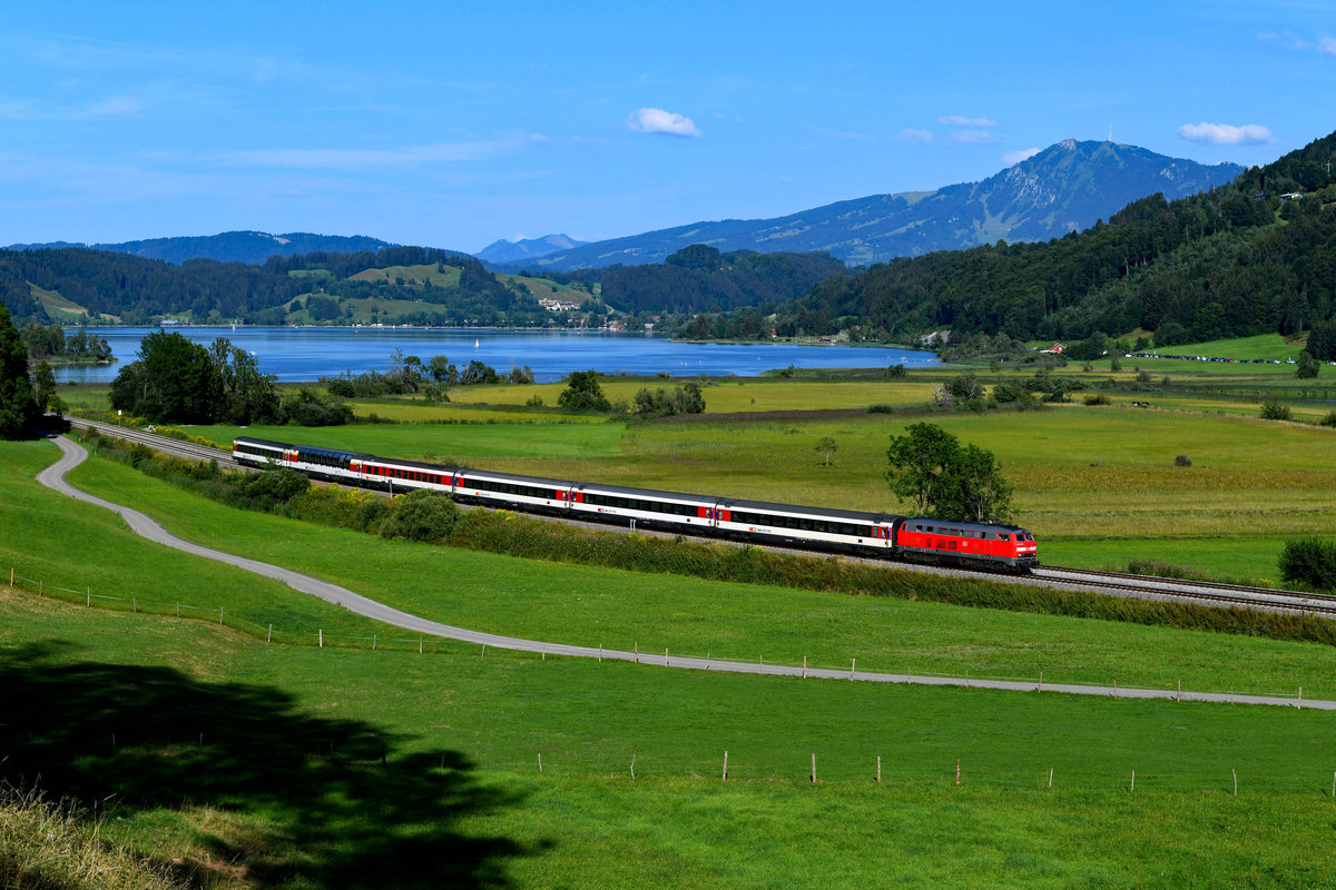 Bei Ratholz ergibt sich dieser schöne Blick auf den Alpsee und auf den Grünten. Am 29. Juli 2018 bestand der EC 192 nach Zürich HB nur aus sechs Wagen und einer Lok. Dies war der Motivgestaltung meines Erachtens nach aber durchaus zuträglich. Mit 218 430 war an diesem Tag auch erfreulicherweise eine sehr gepflegte Maschine für diese Leistung eingeteilt. 