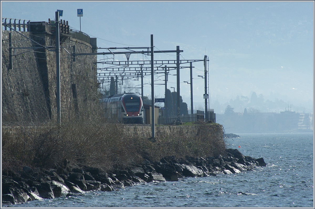 Bei Rivaz, mit viel Zoom gegen das Licht fotografiert, ergab sich eine fast mystische Stimmung, als ein SBB RABe 511 bei der Haltestelle in St-Saphorin durch fuhr. Zudem ist im Hintergrund schemenhaft Vevey zu erahnen.
4. März 2017