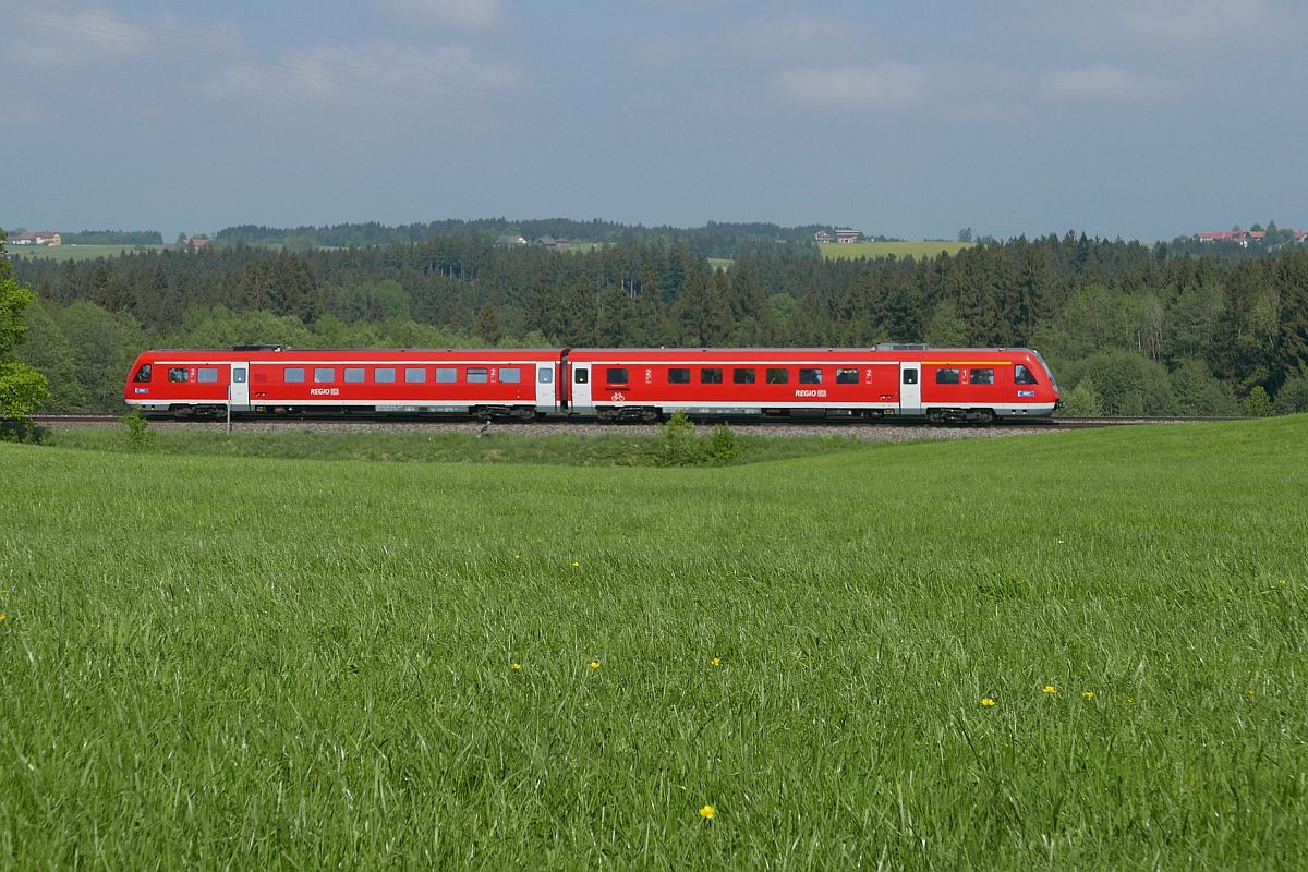 Bei Röthenbach fährt RE 3984 von Lindau kommend am 06.05.2018 durch das hügelige Allgäu nach Ulm.