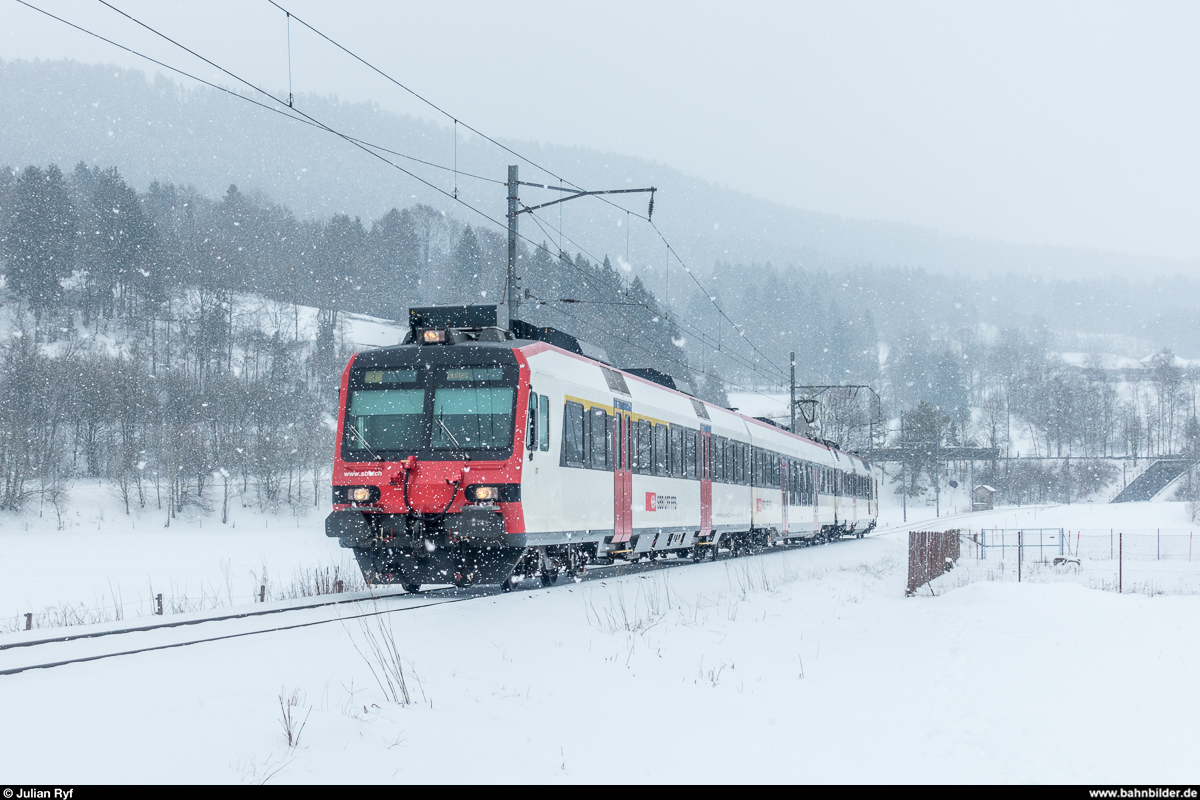 Bei Schneefall bietet selbst ein  langweiliger  Domino ein schönes Fotomotiv. Am 3. März 2018 ist ein solcher auf der TransN-Strecke von Neuchâtel nach Buttes unterwegs kurz vor der Haltestelle La Presta Mines d'Asphalte.