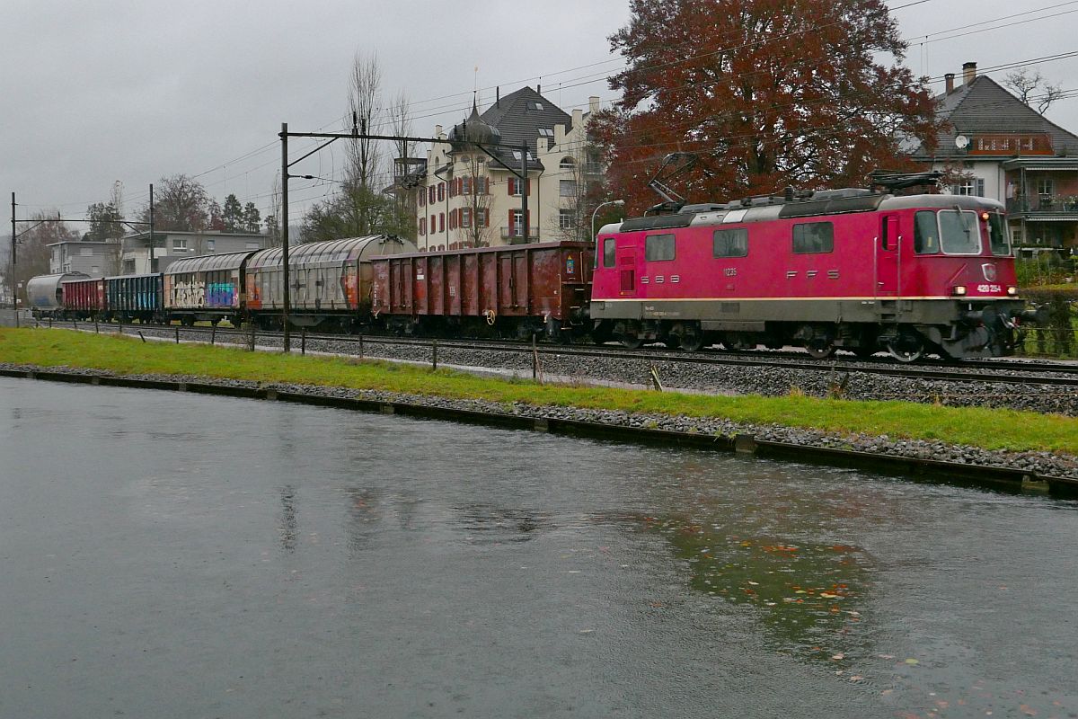Bei starkem Regen fhrt Re 420 235-4 mit einem kurzen gemischten Gterzug am 29.11.2019 in Brglen (TG) am Thurkanal in Richtung Romanshorn