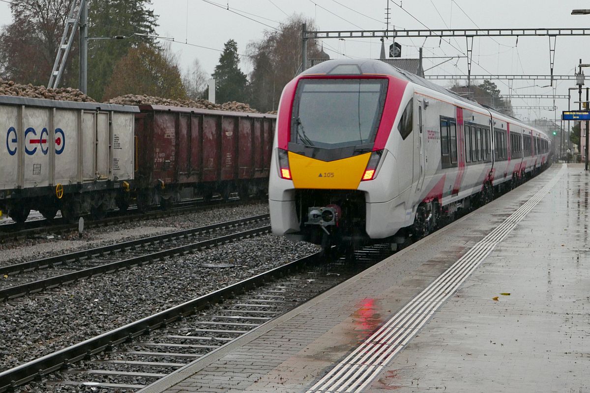 Bei starkem Regen Nachschuss auf den von Re 620 054-7 gezogenen 12-teiligen FLIRT für die in Grossbritannien ansässige Bahngesellschaft Greater Anglia. Der in Richtung Romanshorn fahrende Zug wurde am 29.11.2019 im Bahnhof von Bürglen (TG) fotografiert.