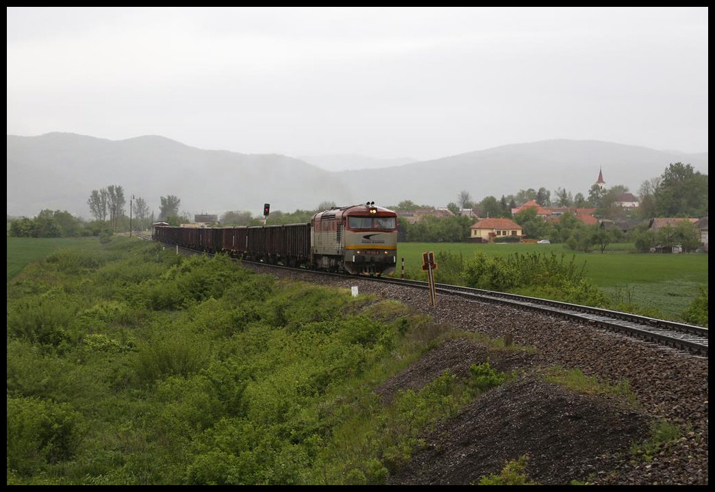 Bei starkem Regenwetter ist hier die Bardotka 751126-4 am 14.5.2019 bei Hucic mit ihrem Güterzug von Lubenik nach Plesivec unterwegs. Am Zugschluss läuft eine Schiebelok mit.