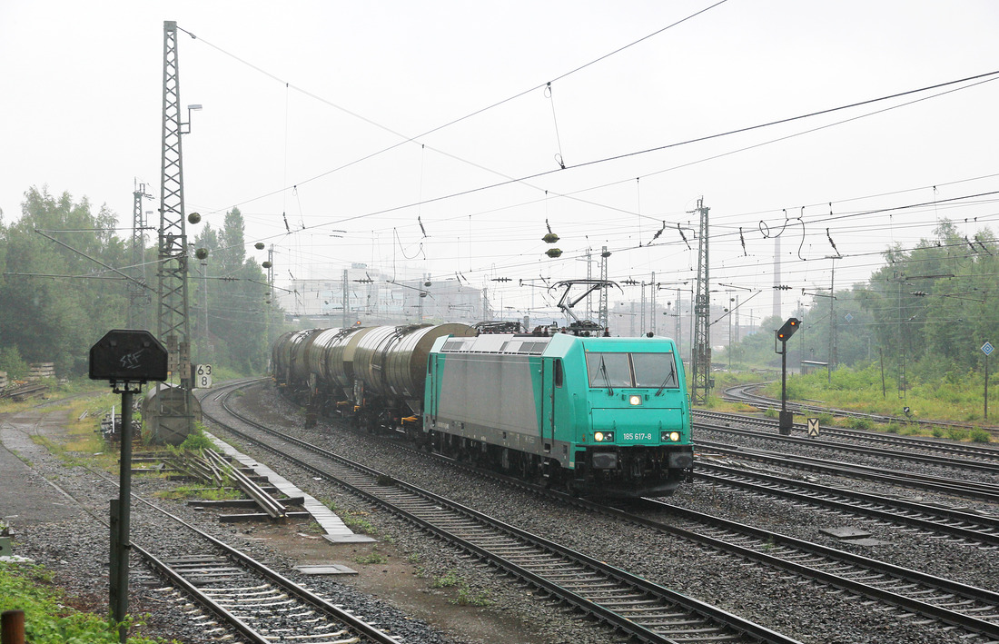 Bei strömendem Regen begegnete mit 185 617 mit einem aus Kesselwagen bestehenden Güterzug.
Aufgenommen in Minden (Westfalen) am 10. Juli 2017.