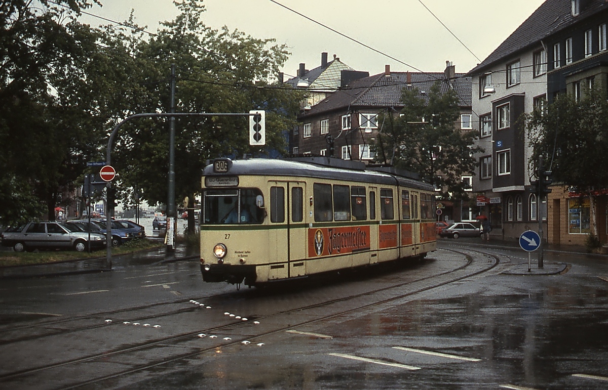 Bei strömendem Regen überquert der GT6ZR 27 um 1990 auf seinem Weg nach Bochum-Querenburg die Oskar-Hoffmann-Straße. Nach der Eröffnung des U-Bahn-Tunnels sieht es hier ganz anders aus.