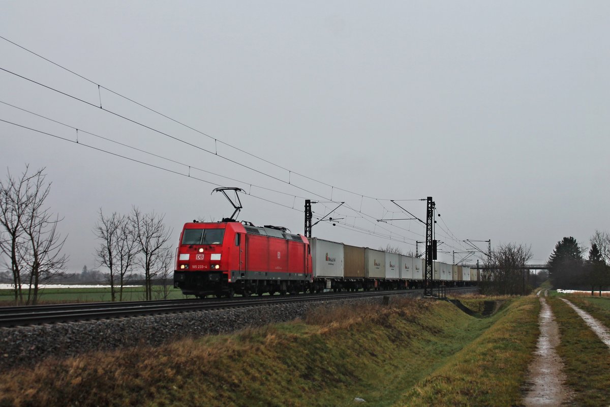 Bei trüben Winterwetter fuhr am Morgen des 20.12.2017 die 185 233-4 mit einem Containerzug, welcher mit Zucker für Italien beladen war, bei Hügelheim über die KBS 703 in Richtung Basel.
