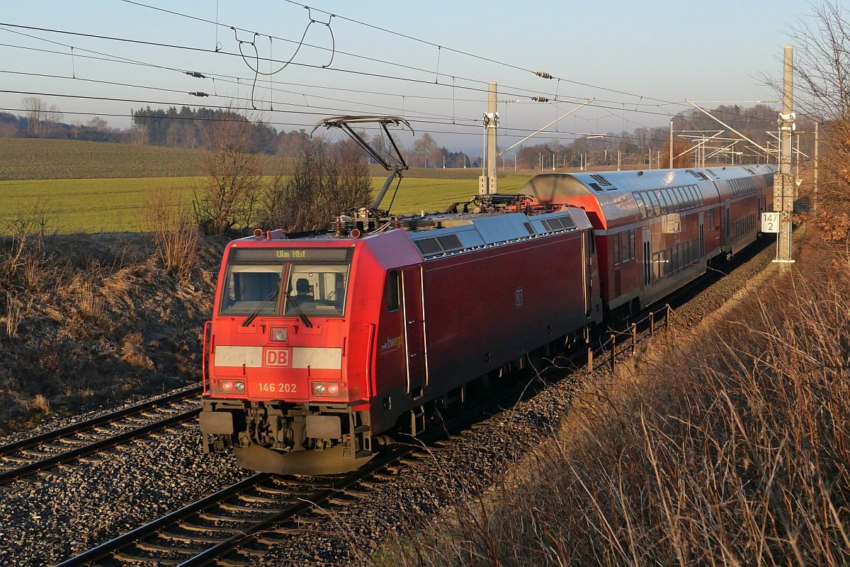 Bei Wattenweiler schiebt 146 202 am 14.02.2023 die von Lindau-Reutin kommenden Wagen des RE 5 / 4246 nach Ulm