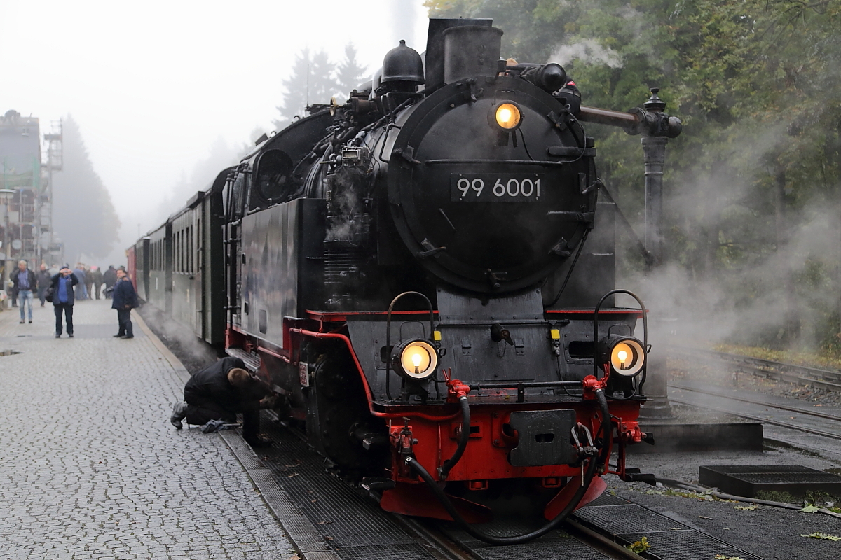 Beim Stop des IG HSB-Sonderzuges am 16.10.2015 im Bahnhof Drei Annen Hohne, wird die Zeit des Wasserfassens vom Lokpersonal von 99 6001 für eine kleine Reparatur am Triebwerk genutzt.