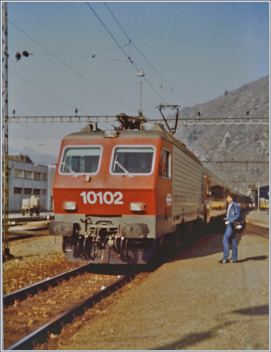 Beiwerk im Bild - keine Erfindung unsere Tage...
In Brig wartet die Re 4/4 IV mit dem Schnellzug 321 Genève/Bern - Brig - Milano - Venezia auf die Abfahrt.
19. April 1984