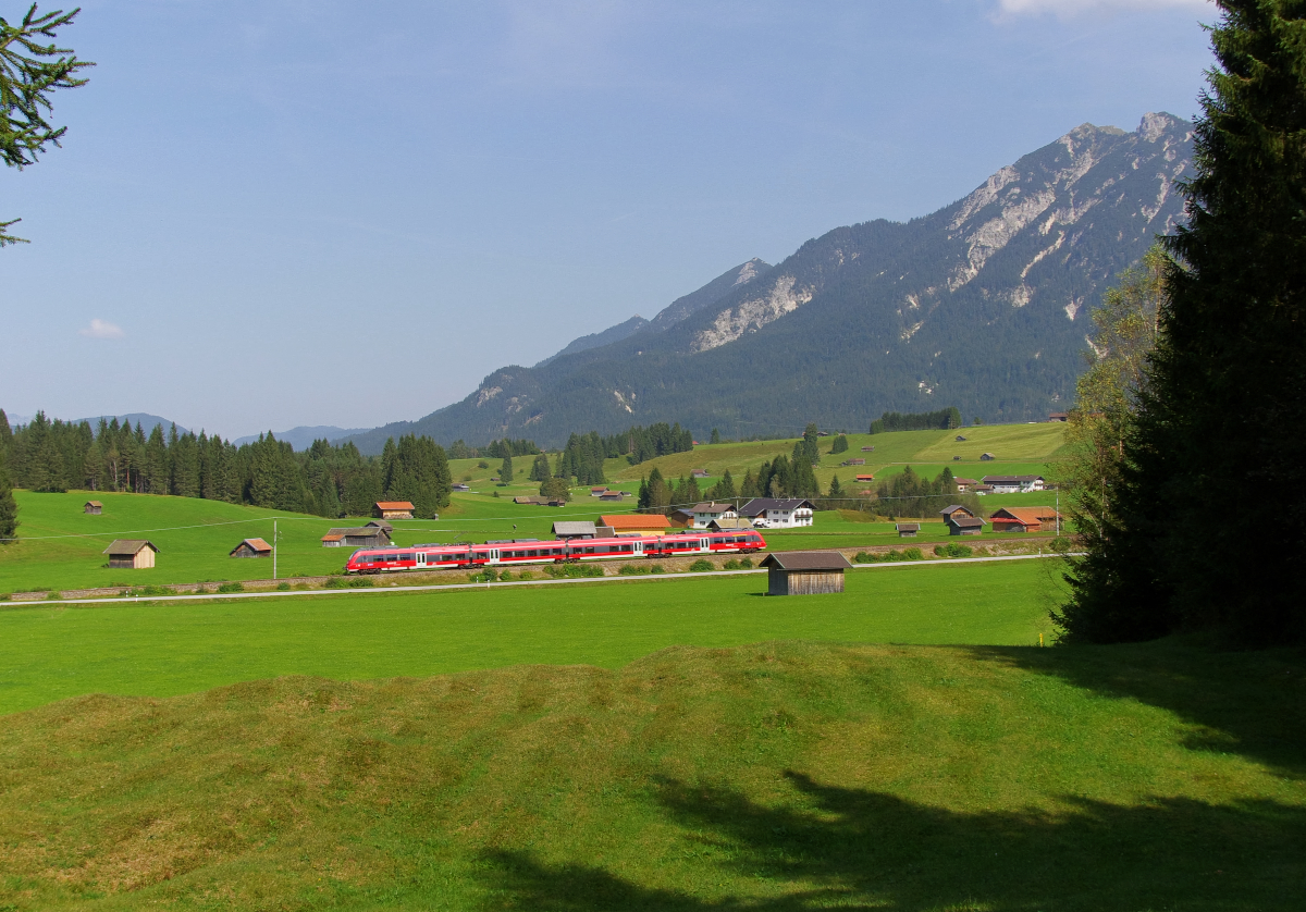 Bekannt ist die Gegend um Mittenwald nicht nur durch das Karwendelgebirge und die nebelfreie Lage, sondern auch durch die Buckelwiesen. Die RB Mittenwald - München rollt die Schmalenseehöhe in Richtung Klais hinab. Bahnstrecke 5504 München - Mittenwald am 12.09.2016
