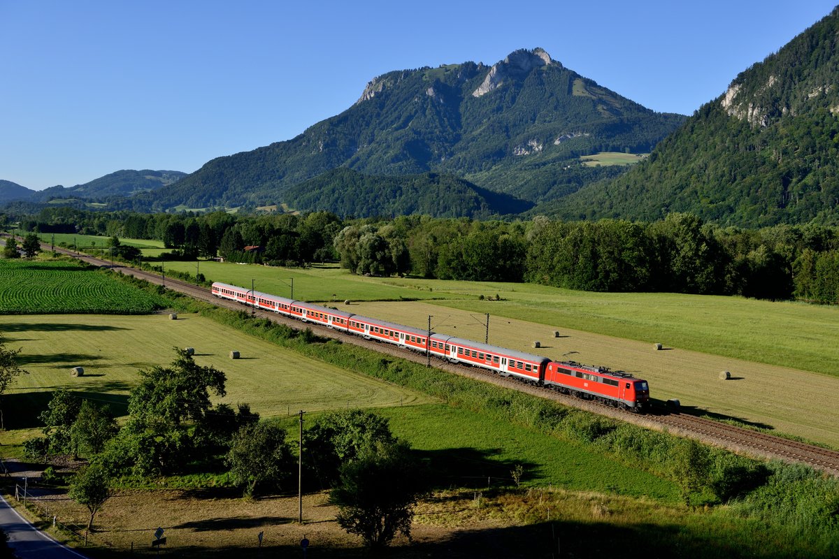 Bereits Geschichte: nur an den längsten Tagen im Jahr ließ sich der RE 79087 im Inntal ablichten. Kurz vor 19 Uhr wurde am 23. Juli 2013 die Fotostelle von 111 227 mit ihrer n-Wagen Garnitur bei Flintsbach passiert, im darauf folgenden Jahr war hier dann bereits die Bayerische Oberlandbahn mit dem Zugangebot MERIDIAN aktiv.