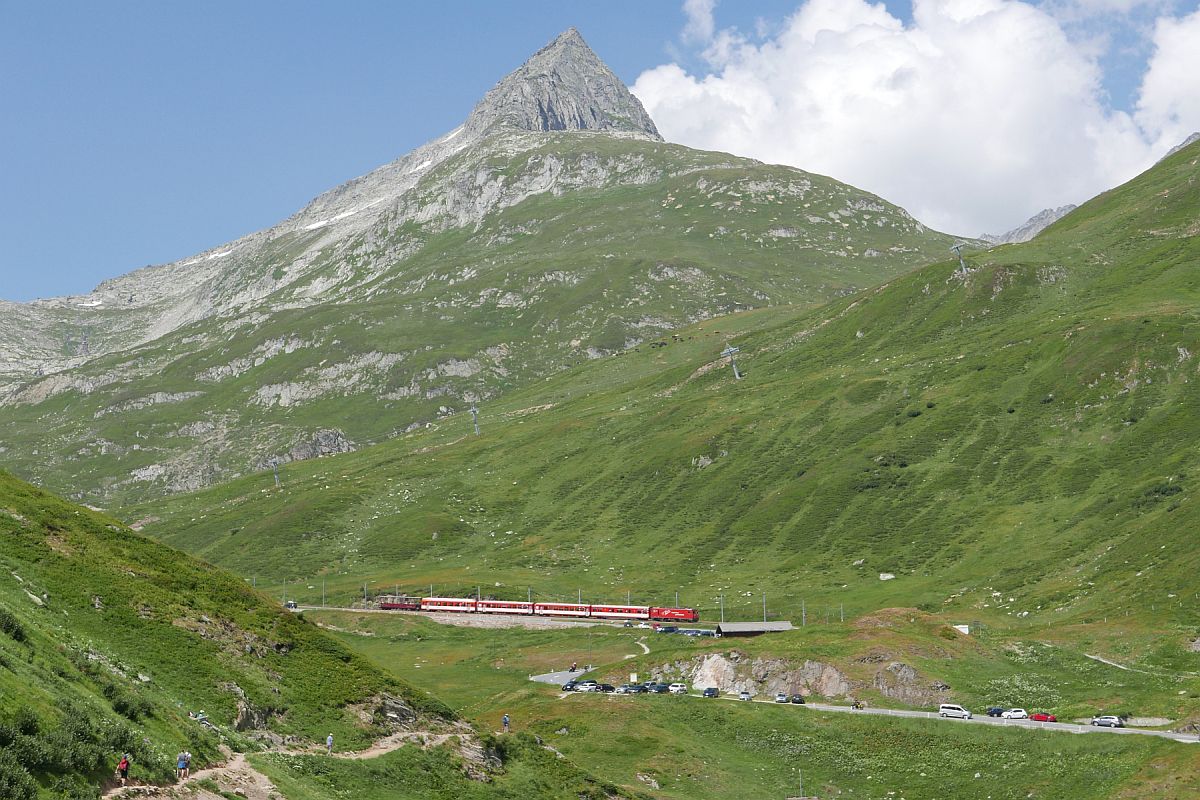 Bergblick auf den 3.096 m hohen Piz Giuv und Talblick auf den in Andermatt gestarteten R 844, der sich kurz nach der Station am Oberalppass auf der Fahrt nach Disentis-Mustér befindet (04.08.2018).