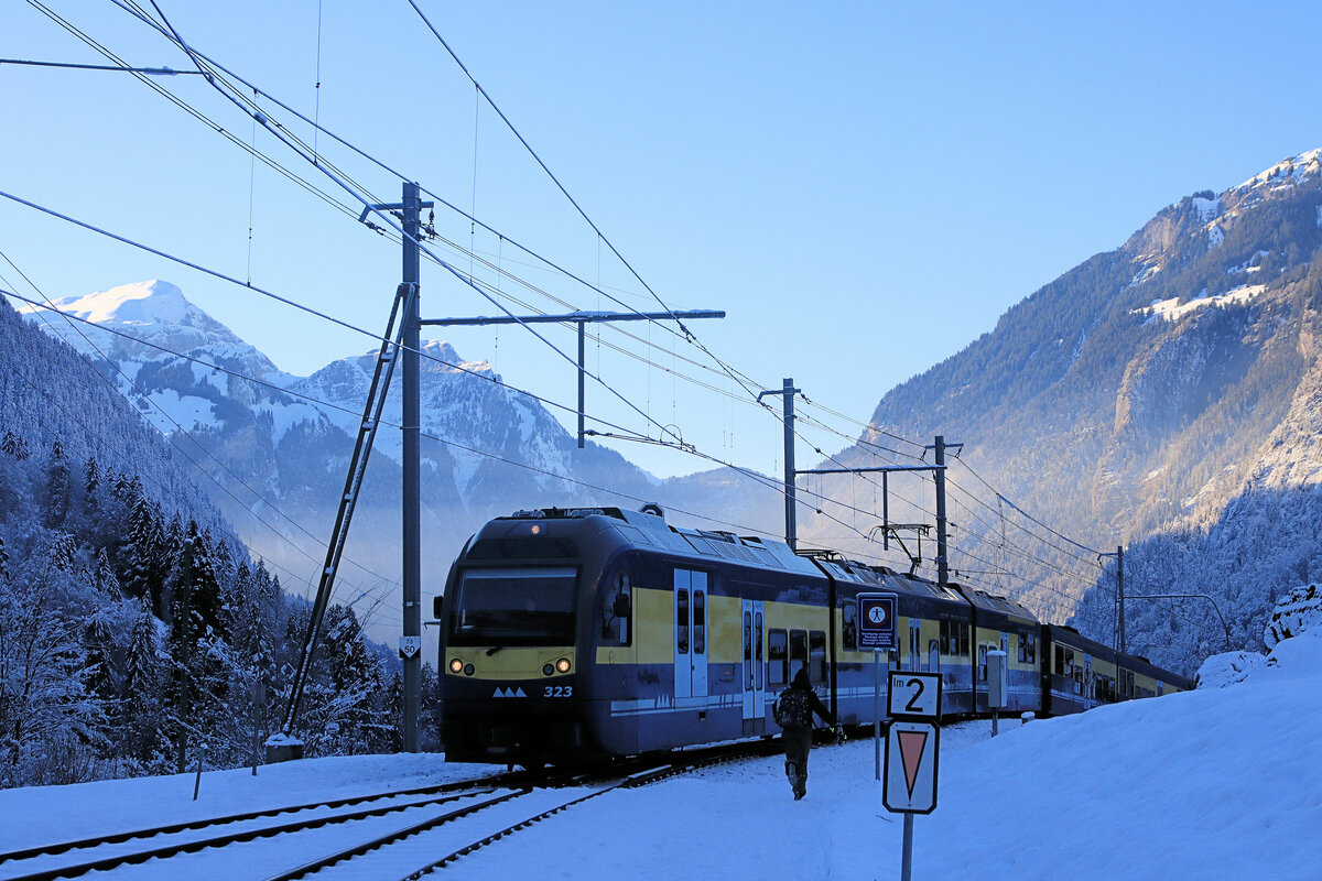 Berner Oberland Bahn, Burglauenen: Triebwagen 323 mit Steuerwagen 422 hat die Talstufe erklommen und fährt in die Station Burglauenen ein. 12.Januar 2024 