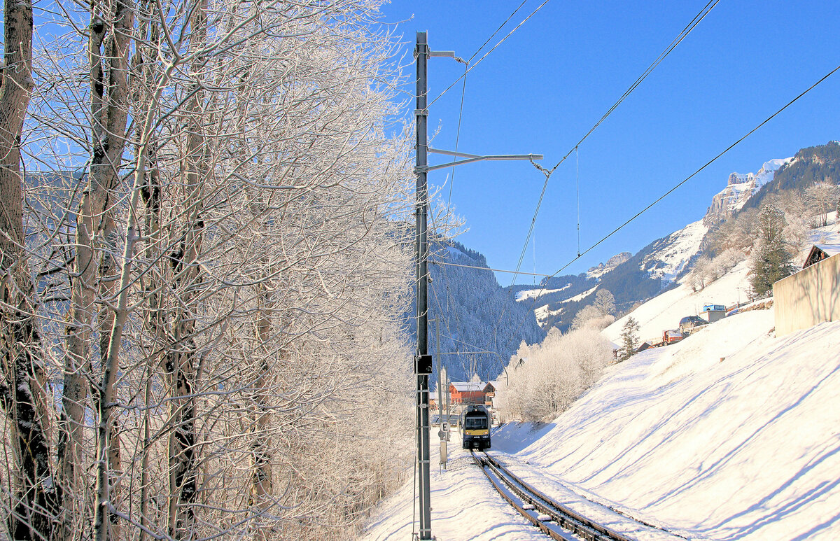 Berner Oberland Bahn, die neue Station Grindelwald Terminal: Gerade unterhalb der Station befindet sich die Einfahrt in den Zahnstangenabschnitt hinauf nach Grindelwald. Das E zeigt, von oben her gesehen, das Ende der Zahnstange an, während der heraufkommende Zug (Triebwagen 322) diese Tafel von der anderen Seite sieht, auf der ein A (Anfang) steht. 12.Januar 2024  