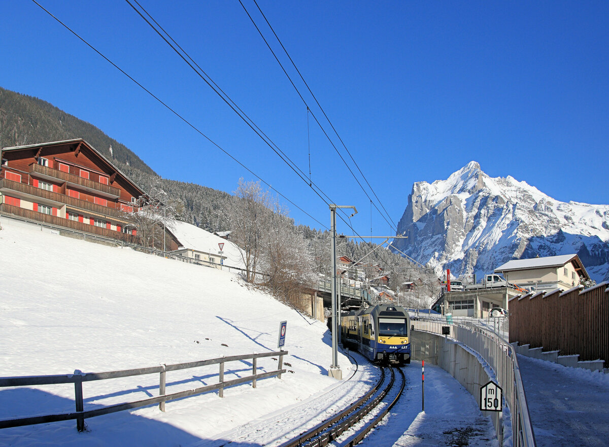 Berner Oberland Bahn, die neue Station Grindelwald Terminal: Diese Station in der Zahnstangenrampe unterhalb von Grindelwald wurde zur Bedienung der neuen Luftseilbahn (Dezember 2019 auf den Männlichen, Dezember 2020  Eiger Express  zum Eigergletscher) im Dezember 2019 eröffnet. Mit dem Wetterhorn vor einem einem strahlend blauen Himmel im Hintergrund fährt Steuerwagen 433 in die Station ein. 12.Januar 2024 