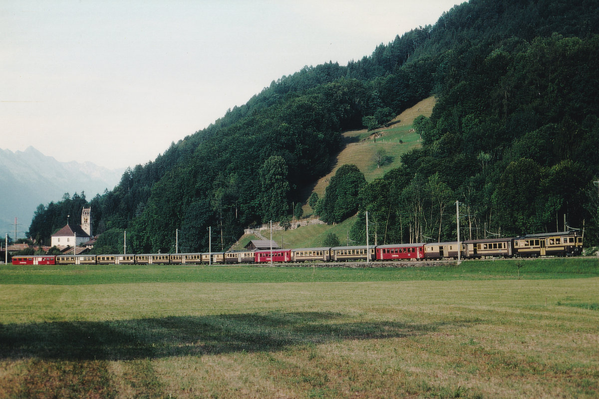Berner-Oberland Bahn/BOB.
Die Regionalzüge ab Interlaken Ost nach Grindelwald und Lauterbrunnen verkehren bis Zweilütschinen vereint.
Die Aufnahme dieses stattlichen Zuges mit Brünigwagen verstärkt, ist im Juli 2003 bei Wilderswil erlegt worden.
Foto: Walter Ruetsch 