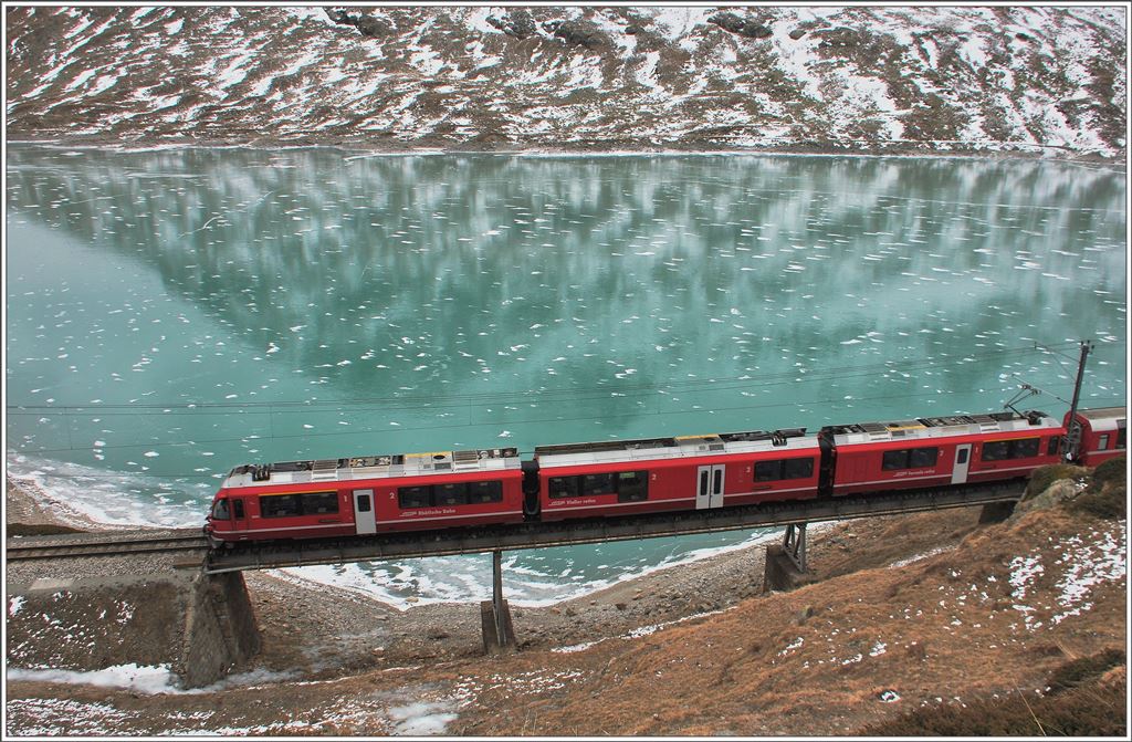 Bernina Express 951 mit Abe 8/12 3504 und gefrorenem Lago Bianco bei Ospizio Bernina. (28.11.2015)