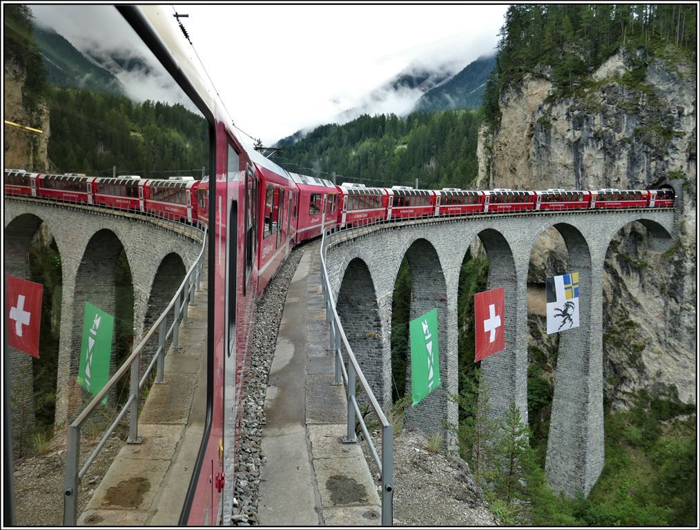 Bernina Express PE 950 auf dem Landwasserviadukt. Der Kanton St.Gallen ist im September Gastkanton bei der RhB, weshalb die grüne Flagge am Viadukt hängt. (06.09.2019)
