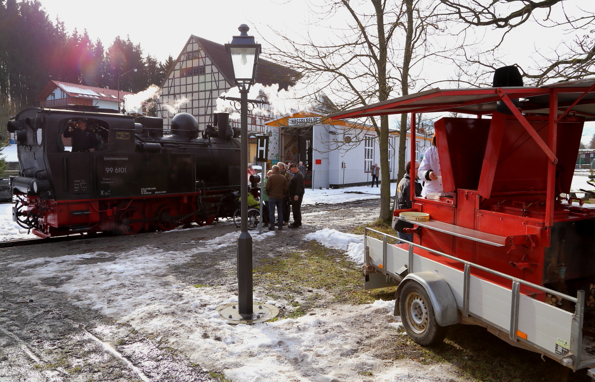 Beschauliche Mittagsruhe am 14.02.2015 im Bahnhof Hasselfelde. Nachdem 99 6101 mit Wasser versorgt wurde, löscht nun auch der Lokführer seinen Durst, während es an der Gulaschkanone Erbsensuppe und Bockwurst gibt. Das ganze fand im Rahmen ein IG HSB-Sonderzugfahrt statt.