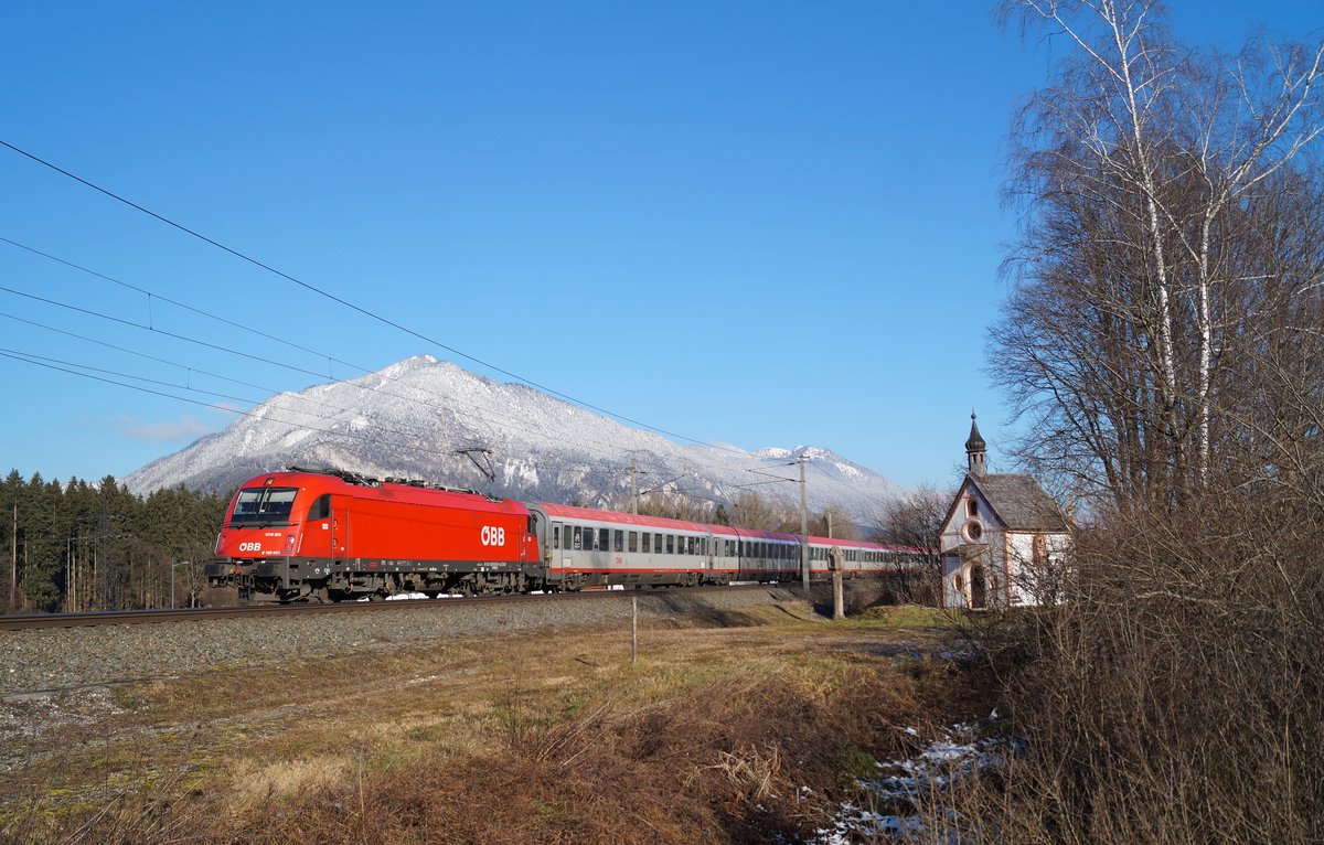 Bestes Wetter für eine exklusive Leistung: Bei winterlichen Temperaturen befördert die frisch lackierte 1216 003 den EC 87 (München Hbf - Venezia Santa Lucia) bei Brixlegg Richtung Süden und lässt die Hagauer Antoniuskapelle hinter sich. (29.12.2019)