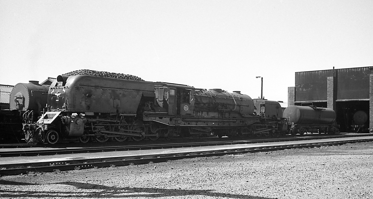 Beyer-Garratt-Lokomotiven der South African Railways: Eine GMAM im November 1976 im Depot Voorbaai mit zusätzlichem Wasserwagen. Von diesen Lokomotiven mit der Achsfolge 2'D1'+1'D2'h4t lieferten Henschel, Beyer-Peacock und die North British Locomotive Company zwischen 1954 und 1958 insgesamt 120 Exemplare. Die letzten wurden erst 1988 abgestellt, einige davon weiter nach Simbabwe verkauft.