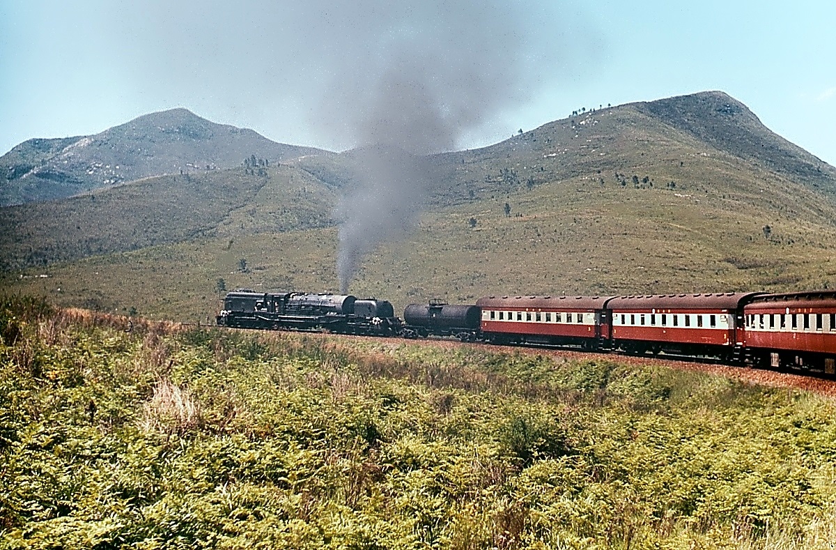 Beyer-Garratt-Lokomotiven der South African Railways: Zwischen George an der Garden Route in der Kapprovinz und Oudshoorn in der Kleinen Karoo bilden die bis zu 1.500 hohen Outeniqua Mountains ein nur schwer zu überwindendes Hindernis. Trotzdem wurde schon 1913 eine Bahnlinie zwischen den beiden Städten über den Montagu-Pass eröffnet, die mit engen Kurven und einer fast durchgängigen Steigung von rd. 3 % auf 24 km 715 m Höhenunterschied bewältigt. Für eine derartige Strecke waren die GMAM prädestiniert und daher auch im November 1976 noch unentbehrlich. Glücklicherweise war mein Schlafwagen nach Port Elizabeth als letzter im Zug eingereiht und so konnte ich zahlreiche Fotos und Filmaufnahmen von dieser imponierenden Bergfahrt machen.