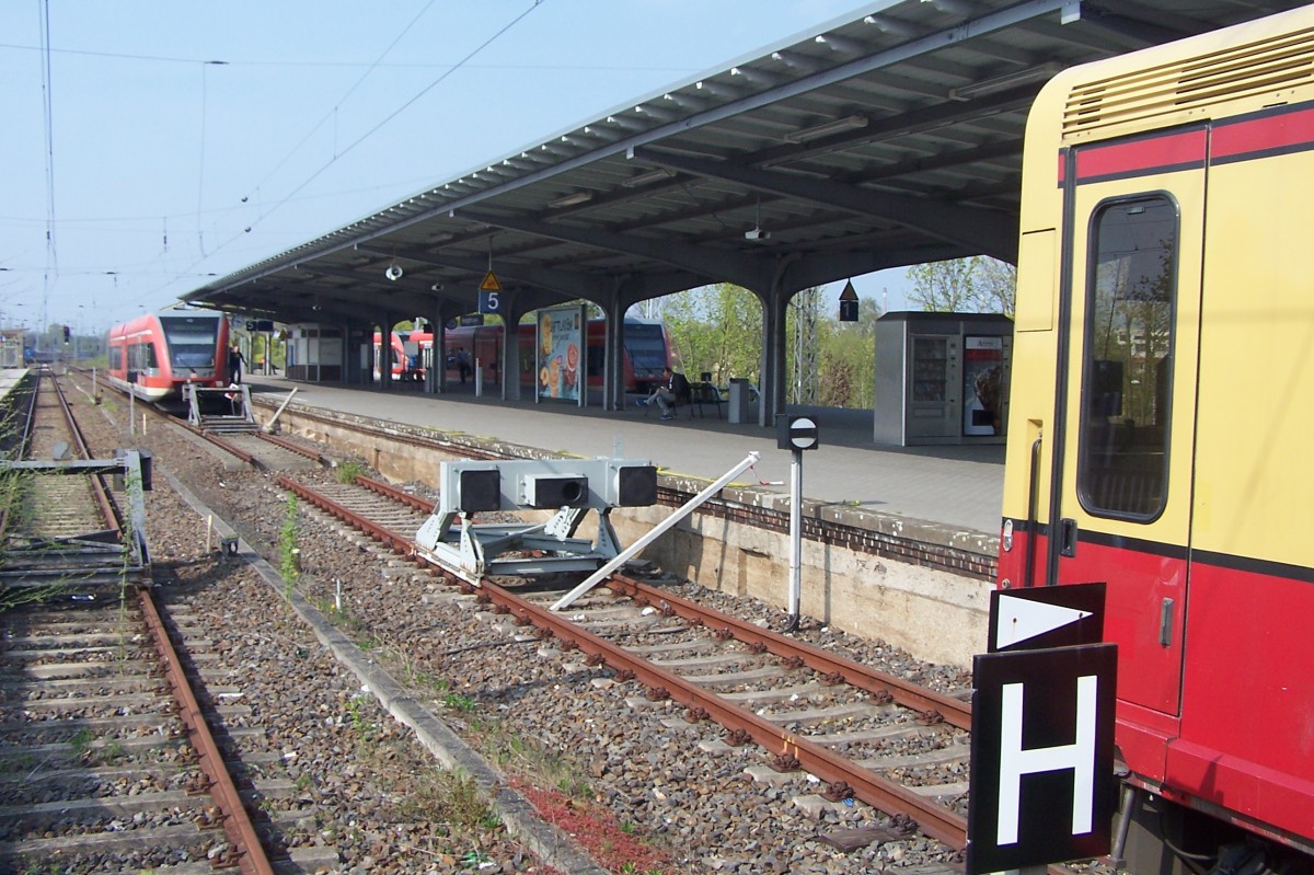Bf. Hennigsdorf bei Berlin 25.4.2015. Früher war das mal ein Durchgangsbahnhof. Zu DDR-Zeiten wegen der Unterbrechung der S-Bahn ein Kopfbahnhof. Bis zu Elektrifizierung in den 80-er Jahren gabs noch eine S-Bahn die auf dem Streckenrest zwischen Hennigsdorf und Velten /Mark pendelte.
Nach Wiederaufbau der S-Bahn-Verbindung nach Berlin hat sich daran eigentlich nichts geändert: Am ehemals gemeinsamen Bahnsteig für S-Bahn und Personenzüge stehen sich jetzt zwei Prellböcke gegenüber (Im Vordergrund eine S-Bahn, im Hintergrund ein GTW der Regionalbahn. Damit ist wohl eine Art  doppelseitiger Kopfbahnhof  geschaffen worden, denn ein durchgehendes Gleis von hier nach Berlin gibt es bis heute nicht!
