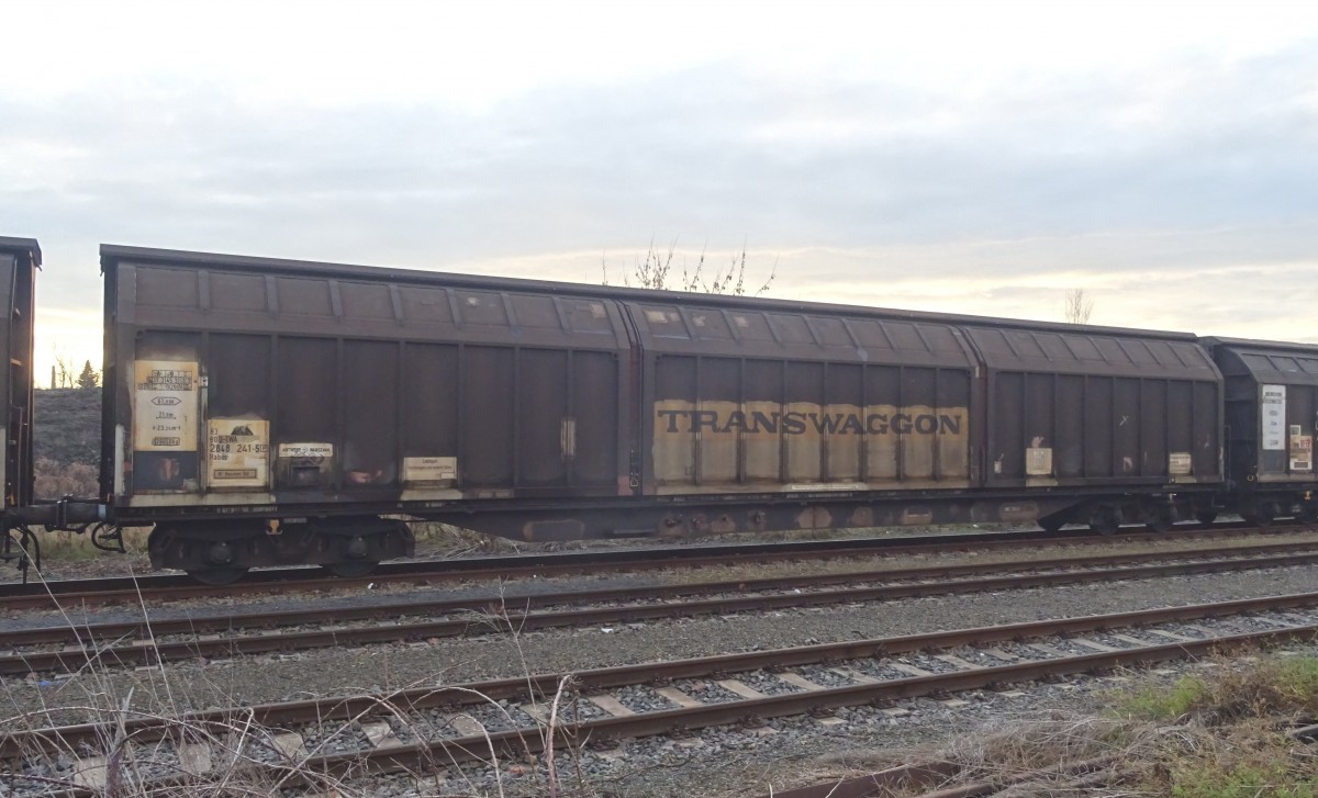 Bf. Nauen/Havelland, 14.12.15. Unterhalb des Regionalbahnhofs liegen noch ein paar Gleise der vormaligen  Osthavelländischen Kreisbahn  (stillgelegt in den 60-er Jahren), die ihre Existenz einem nahegelegenen Werksanschluß eines namhaften Herstellers von Waschmaschinen etc. verdanken. Aus diesem Grund finden sich hier immer zahlreiche Schiebewand-Wagen wie dieser Habiis9 der Transwaggon, die sowohl auf den ehemaligen Kreisbahngleisen, wie auch im Bahnhof selbst abgestellt werden. Die Wagennummer lautet: 83 80 D-TWA 2848 241-5 (P) Habiis 9, Heimat-Bf. Maschen.