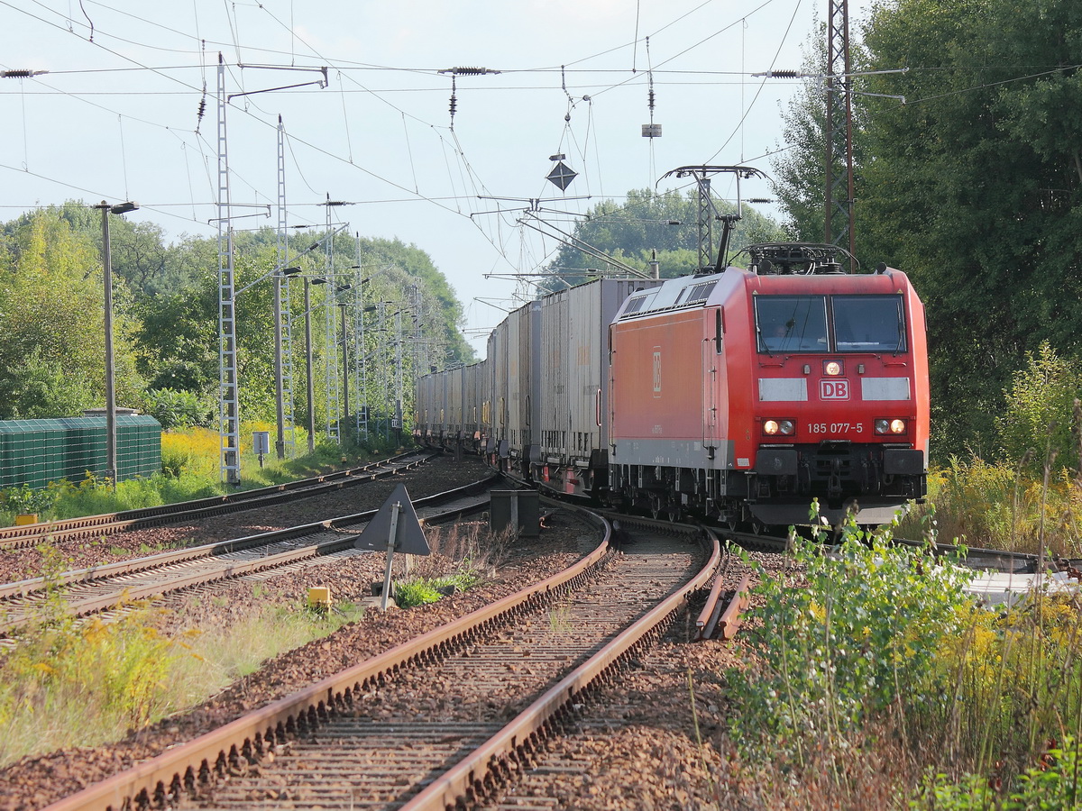 Blankenfelde (Brandenburg) in Hhe des Bahnbergangs am Tunnelweg wechselt 185 077-5   mit einem Containerzug (Continental) auf KBS Strecke 203 zur Weiterfahrt in Richtung Stralsund am 21. September 2013.